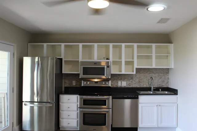 a kitchen with stainless steel appliances granite countertop a refrigerator and a stove top oven