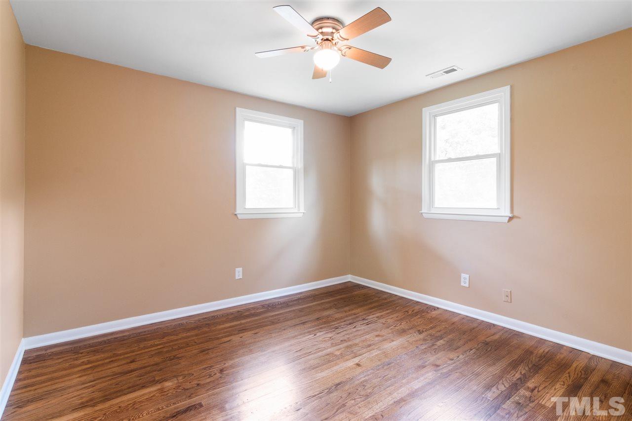 701 Hadley Road Raleigh, NC 27610 - Photo 11 of 16 an empty room with wooden floor and windows