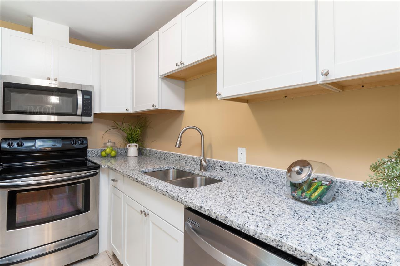 701 Hadley Road Raleigh, NC 27610 - Photo 8 of 16 a kitchen with granite countertop a sink a stove and microwave