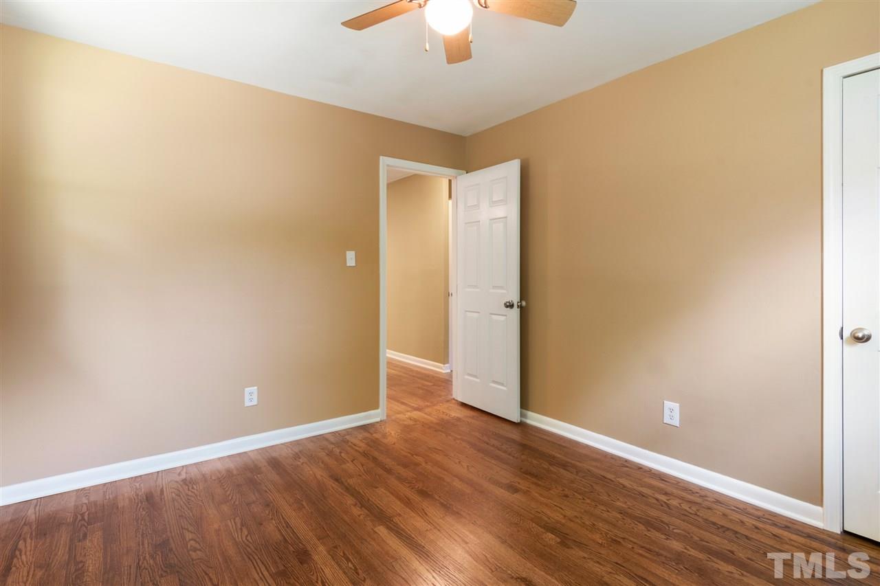 701 Hadley Road Raleigh, NC 27610 - Photo 10 of 16 an empty room with wooden floor and a chandelier fan