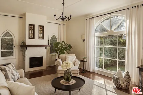 a living room with furniture a fireplace and a chandelier