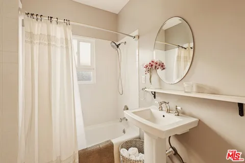 a bathroom with a sink a mirror and a shower