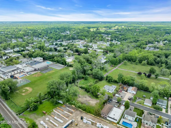 an aerial view of residential houses with outdoor space and trees