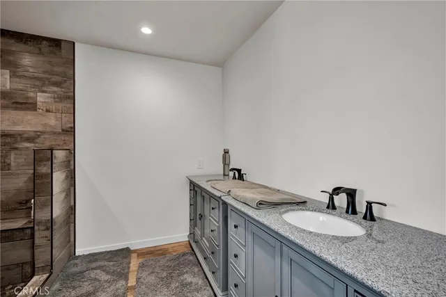 a spacious bathroom with a granite countertop sink and a mirror