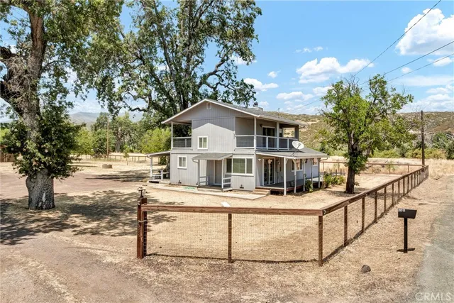 a white house that has tree in front of it