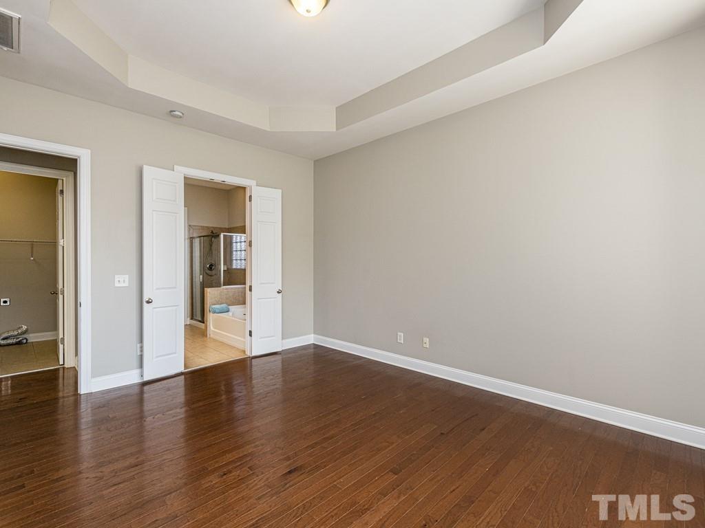 1136 Chapanoke Road Raleigh, NC 27603 - Photo 16 of 30 a view of an empty room with wooden floor and a window