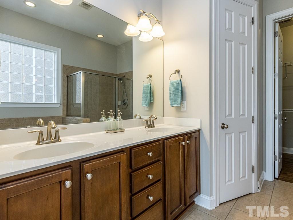 1136 Chapanoke Road Raleigh, NC 27603 - Photo 17 of 30 a bathroom with a double vanity sink and a mirror