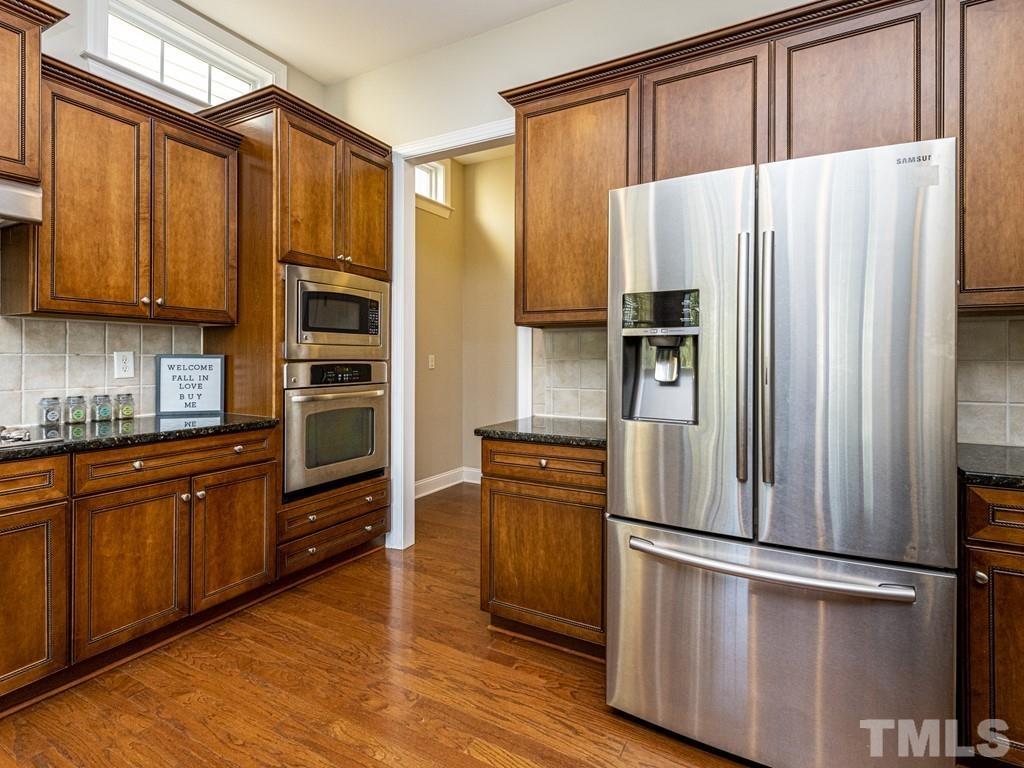 1136 Chapanoke Road Raleigh, NC 27603 - Photo 3 of 30 a kitchen with stainless steel appliances a refrigerator and wooden cabinets