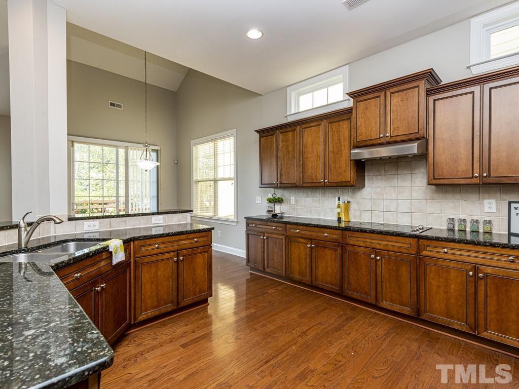 1136 Chapanoke Road Raleigh, NC 27603 - Photo 7 of 30 a large kitchen with stainless steel appliances granite countertop a sink stove and cabinets