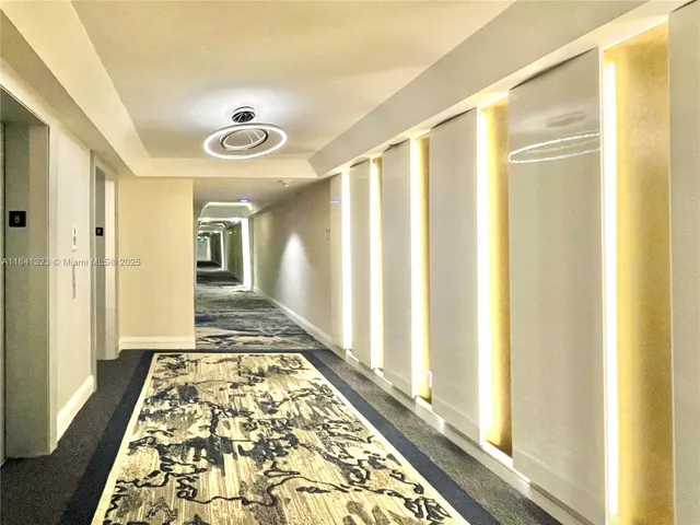 a view of a hallway with wooden floor and a carpet