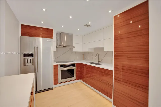 a kitchen with stainless steel appliances granite countertop a sink and a refrigerator