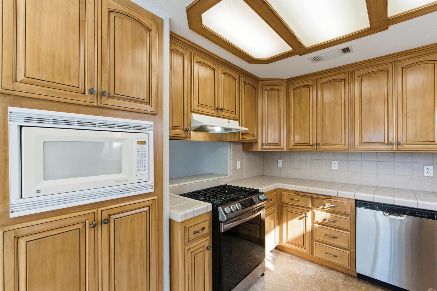 184 South Double Tree Way Madera, CA 93637 - Photo 11 of 37 a kitchen with stainless steel appliances granite countertop a stove and a microwave