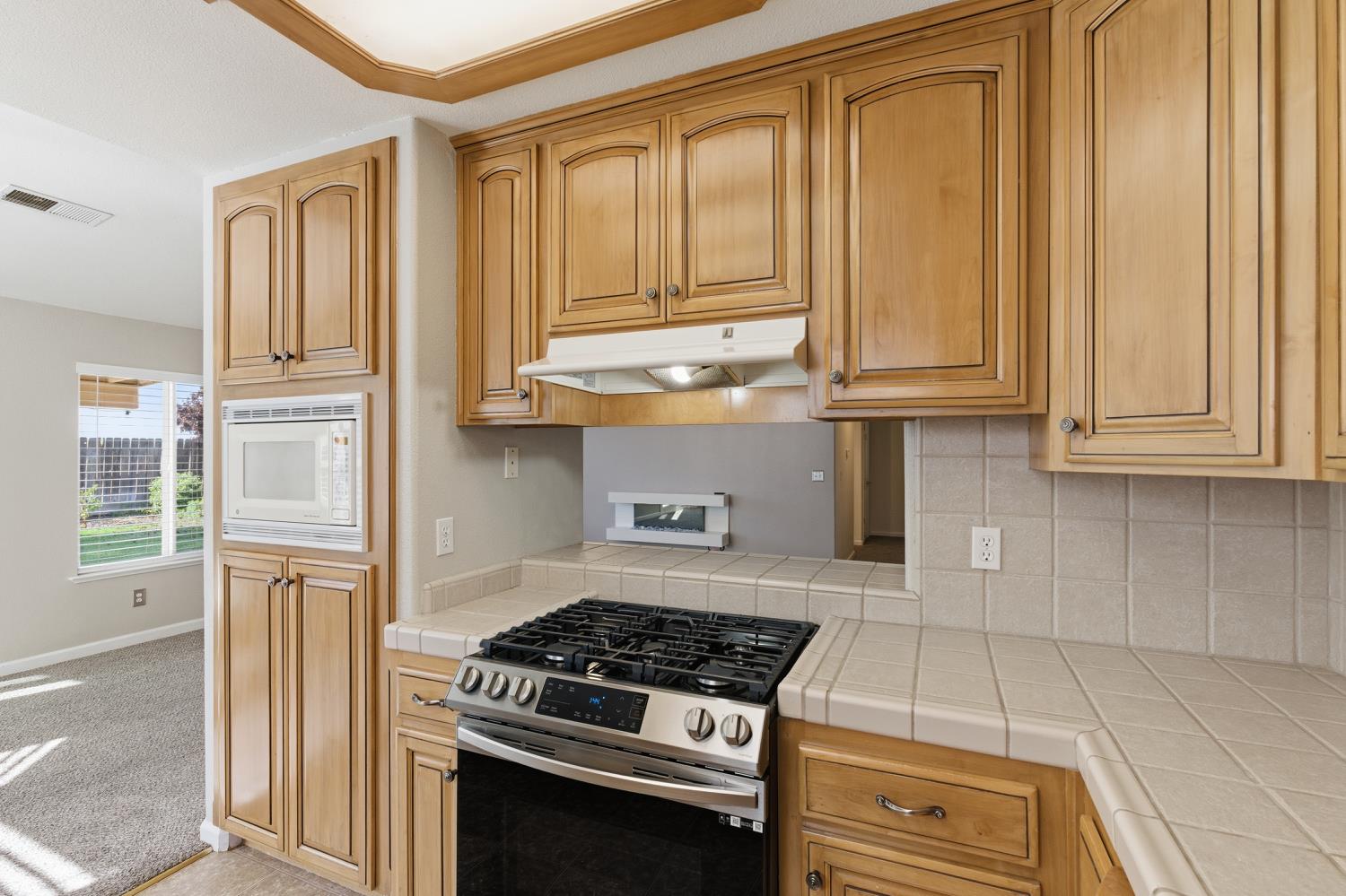 184 South Double Tree Way Madera, CA 93637 - Photo 14 of 37 a kitchen with granite countertop cabinets and black stainless steel appliances