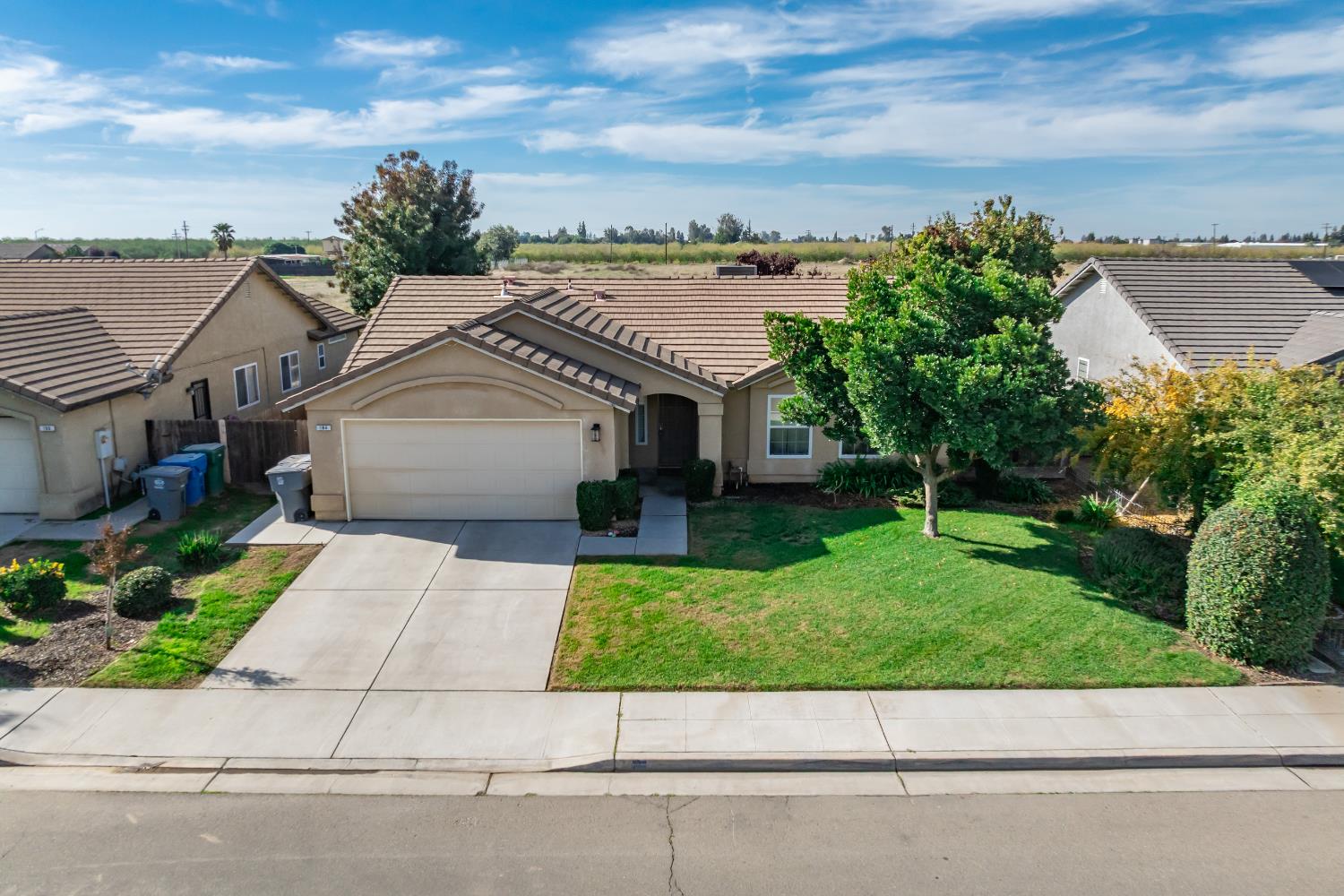 184 South Double Tree Way Madera, CA 93637 - Photo 32 of 37 a view of a house with a garden and a car park side of a road