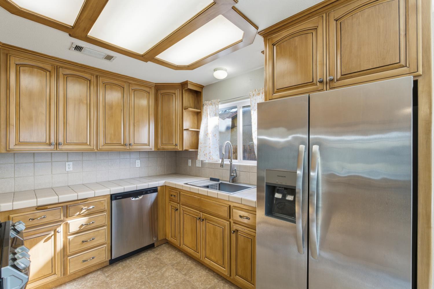 184 South Double Tree Way Madera, CA 93637 - Photo 10 of 37 a kitchen with stainless steel appliances granite countertop a refrigerator a sink and white cabinets