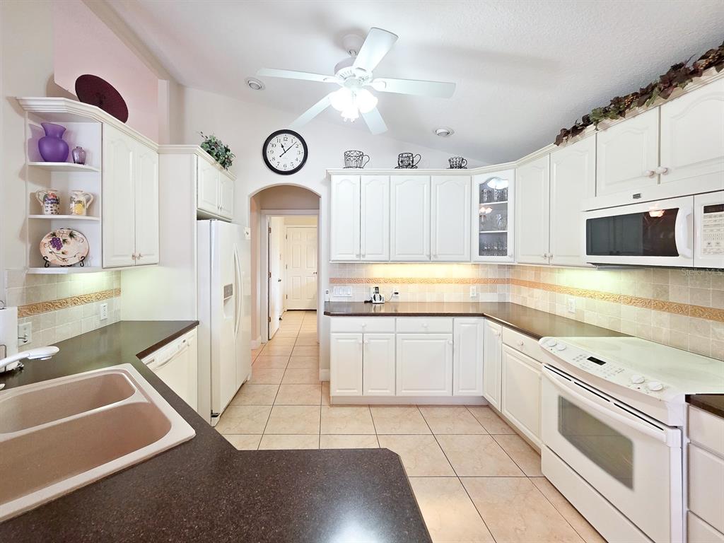 1 Ripley Place Palm Coast, FL 32164 - Photo 21 of 54 a kitchen with granite countertop a stove a sink and a microwave