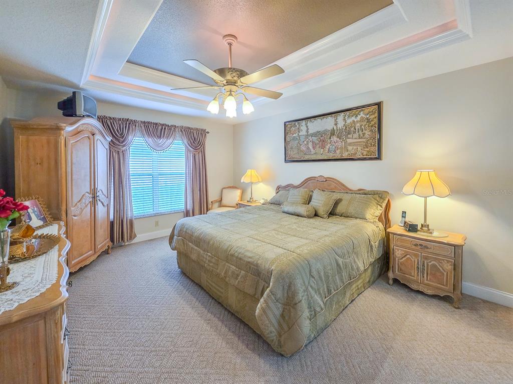 1 Ripley Place Palm Coast, FL 32164 - Photo 24 of 54 a spacious bedroom with a bed and a chandelier