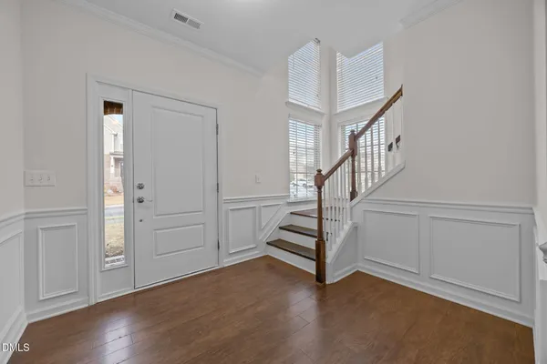 an empty room with wooden floor fireplace and windows