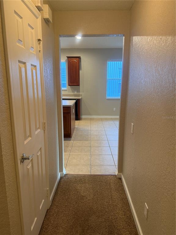 1100 Brant Point Orlando, FL 32828 - Photo 19 of 26 a view of a hallway and an empty room with wooden floor