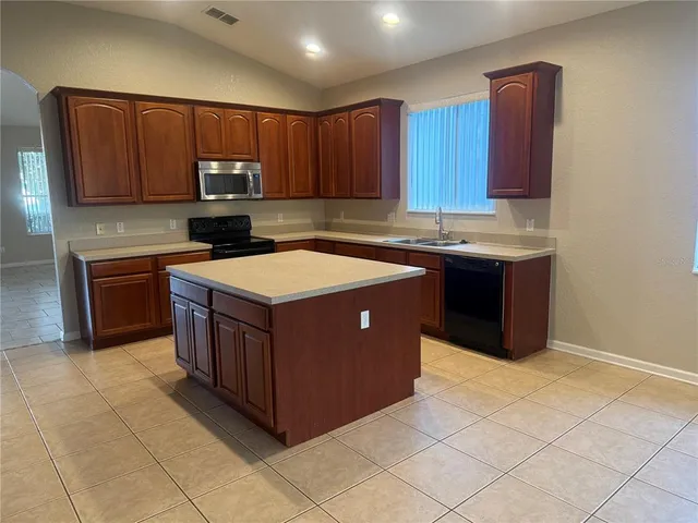 a kitchen with stainless steel appliances granite countertop a stove a sink dishwasher and a refrigerator