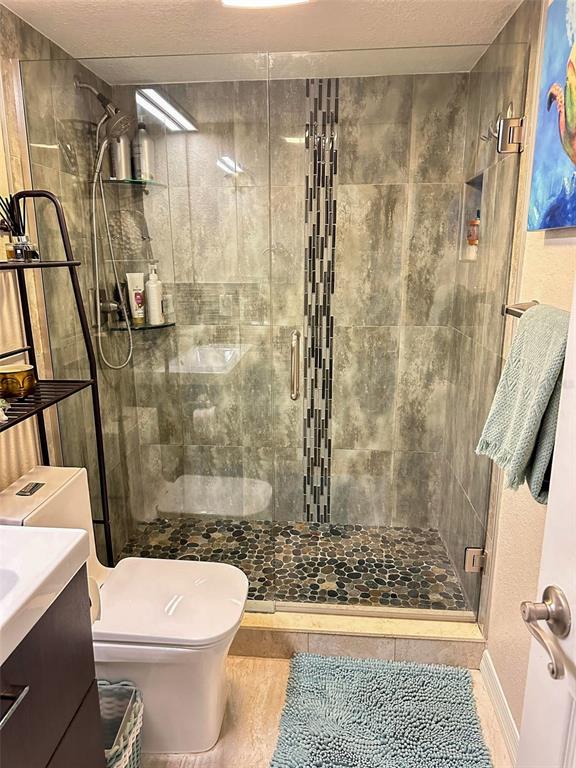 8911 Blind Pass Road, Unit 220 St. Pete Beach, FL 33706 - Photo 28 of 67 a bathroom with a shower and a toilet