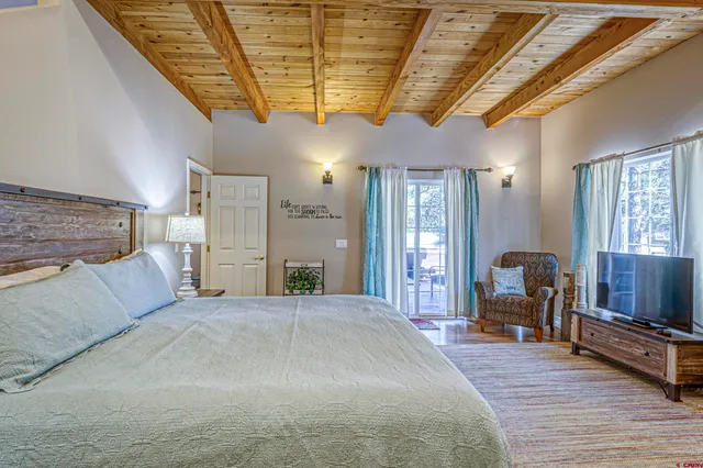 a spacious bedroom with a bed a table and chairs