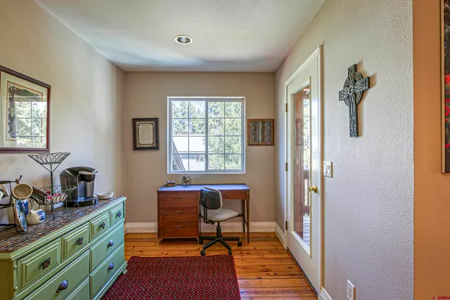 a view of a workspace with furniture and a window