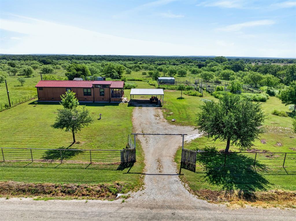 2401 Lamkin Road Mineral Wells, TX 76067 - Photo 1 of 36 a view of a garden with a building in the background