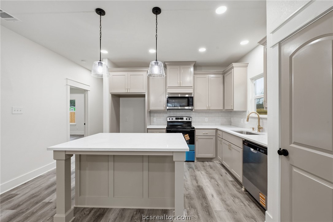 205 Lock Lane Bryan, TX 77803 - Photo 11 of 23 a kitchen with kitchen island a sink stainless steel appliances and cabinets