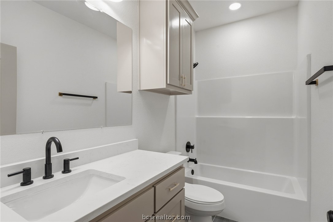 205 Lock Lane Bryan, TX 77803 - Photo 14 of 23 a bathroom with a sink a toilet and shower
