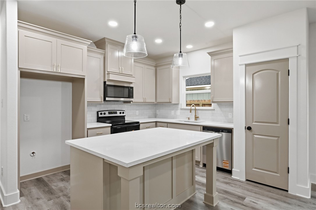 205 Lock Lane Bryan, TX 77803 - Photo 2 of 23 a kitchen with a sink a microwave a stove and refrigerator