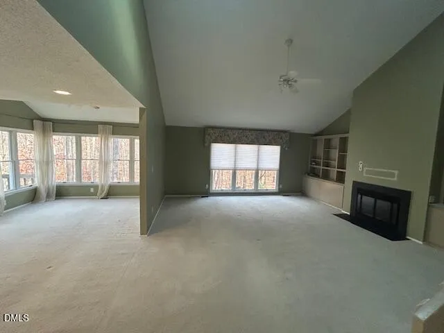 a view of empty room with a fireplace and windows