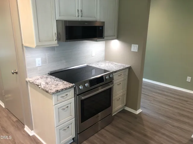 a stove top oven sitting inside of a kitchen