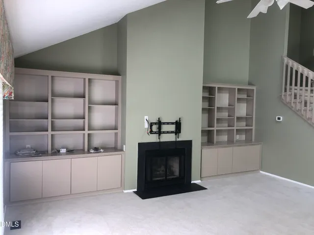 a living room with a fireplace and a walk in closet