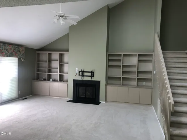 a view of an empty room with a fireplace and a window
