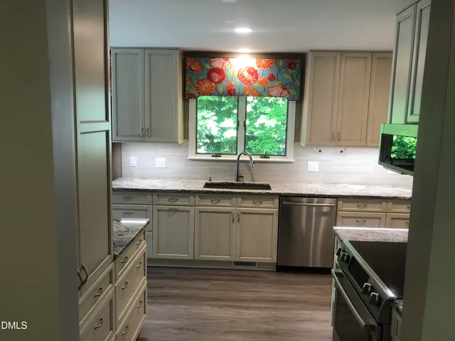 a kitchen with stainless steel appliances granite countertop a sink stove and cabinets