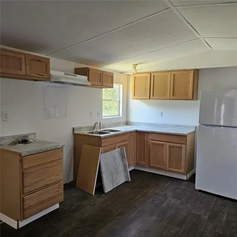 a kitchen with granite countertop white cabinets and white appliances