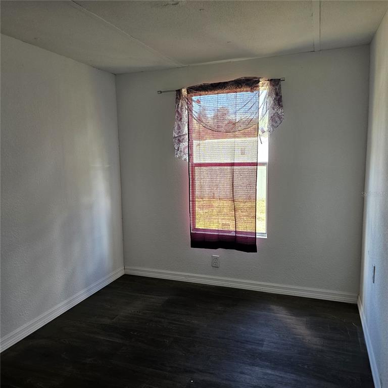 2603 Ince Drive Ruskin, FL 33570 - Photo 8 of 10 an empty room with wooden floor and windows