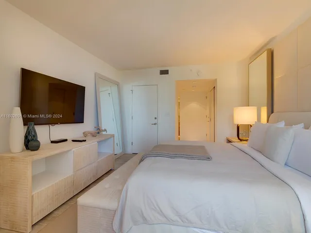 a bedroom with a flat screen tv and a bed