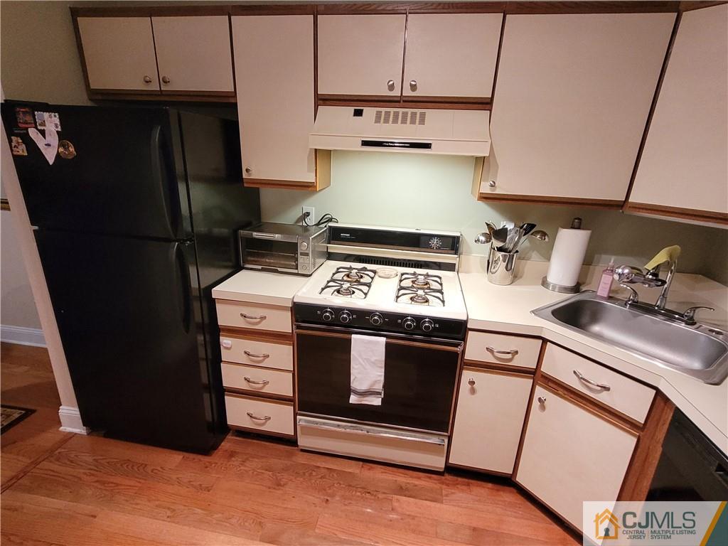 2705 Ridgefield Court, Unit 2705 Helmetta, NJ 08828 - Photo 3 of 33 a kitchen with stainless steel appliances granite countertop a refrigerator stove and sink
