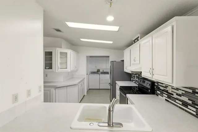 a kitchen with stainless steel appliances a refrigerator and a stove top oven