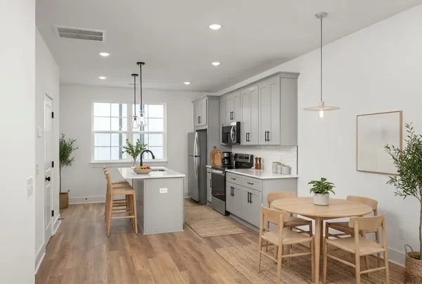 a kitchen with a table chairs refrigerator and cabinets