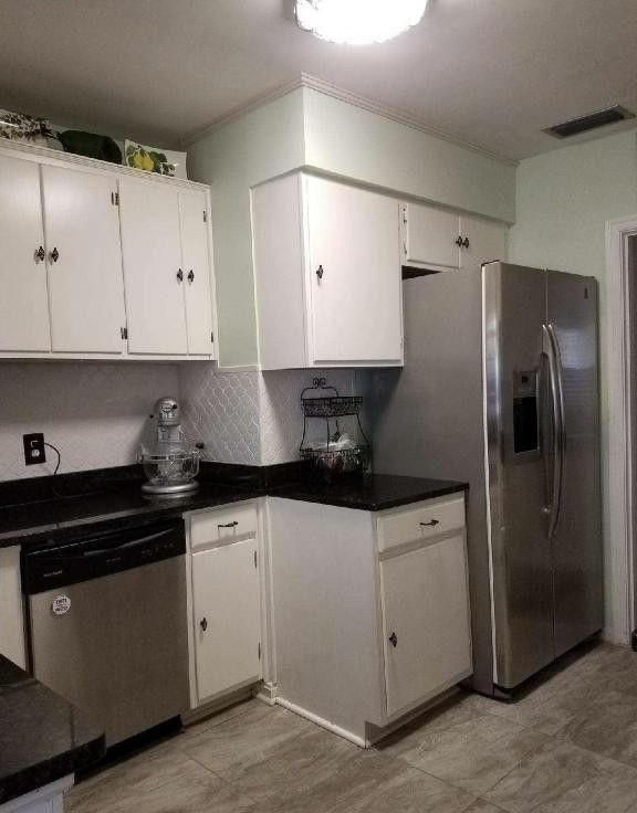 1677 Geraldine Drive Jacksonville, FL 32205 - Photo 16 of 52 a kitchen with granite countertop white cabinets and stainless steel appliances