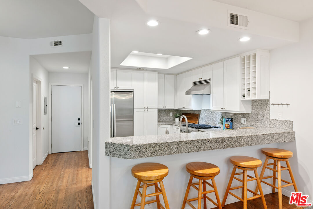 6477 Zuma View Place, Unit 125 Malibu, CA 90265 - Photo 12 of 33 a kitchen with stainless steel appliances granite countertop a sink and a refrigerator