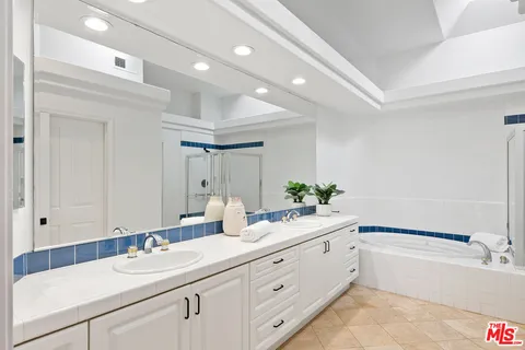 a bathroom with a tub a sink and mirror