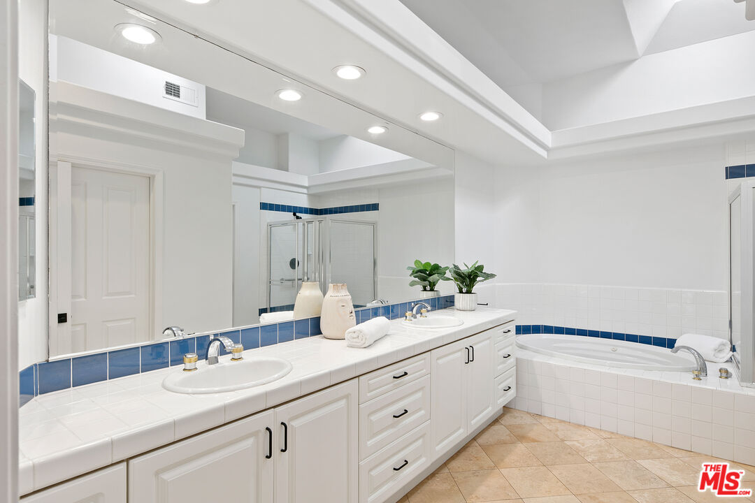 6477 Zuma View Place, Unit 125 Malibu, CA 90265 - Photo 20 of 33 a bathroom with a sink double vanity granite tub shower and a mirror