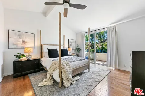 a large bedroom with a bed and wooden floor