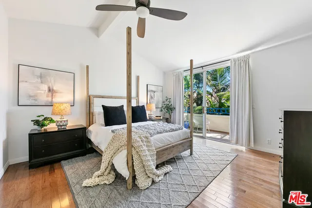 a large bedroom with a bed and wooden floor