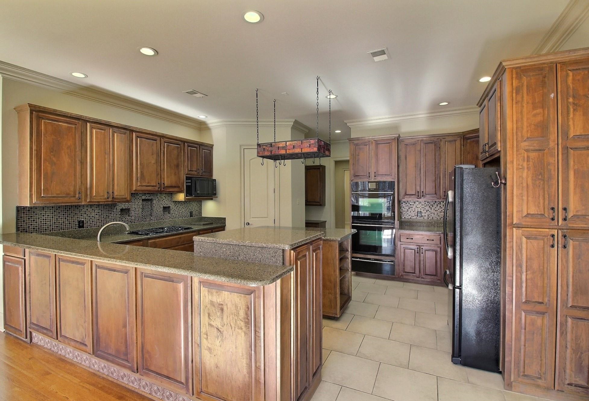 580 Hickory Lake Road Eads, TN 38028 - Photo 13 of 40 a kitchen with stainless steel appliances granite countertop a refrigerator oven a sink dishwasher and wooden cabinets
