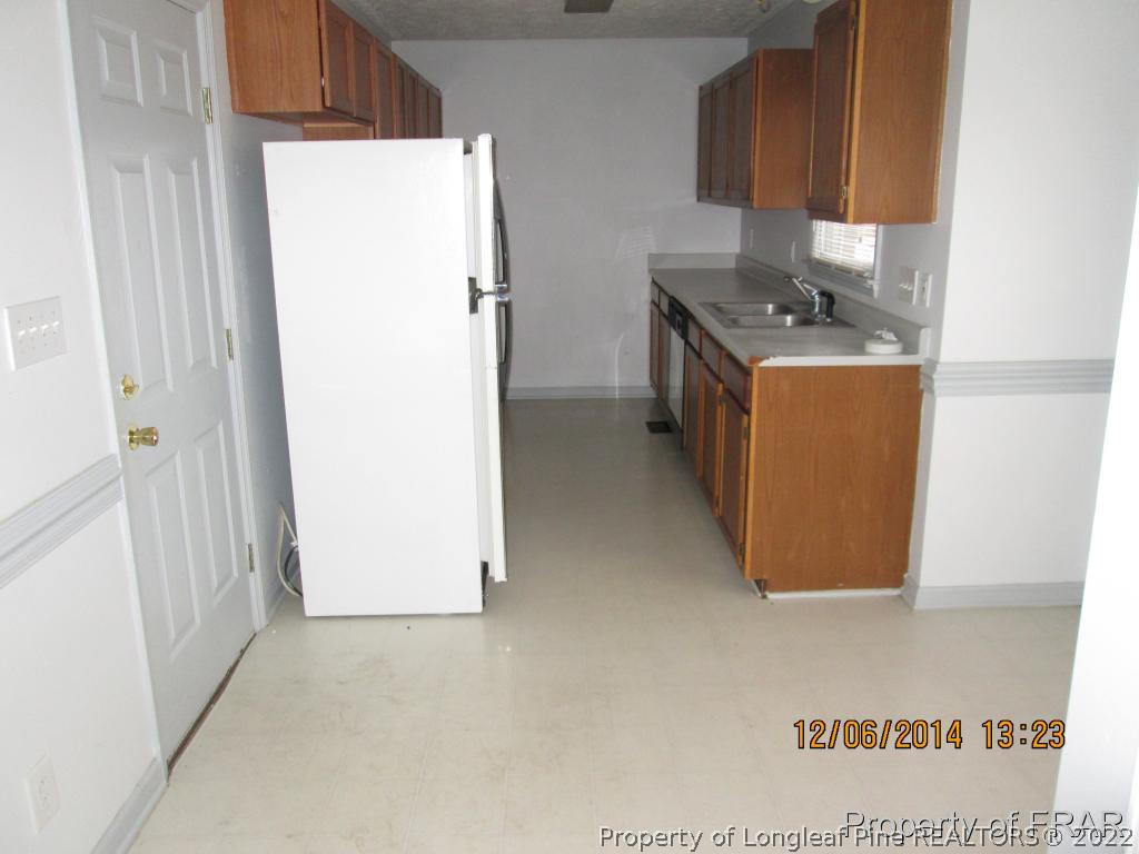 5029 Summer Ridge Road Fayetteville, NC 28303 - Photo 7 of 26 a utility room with fridge and wooden floor